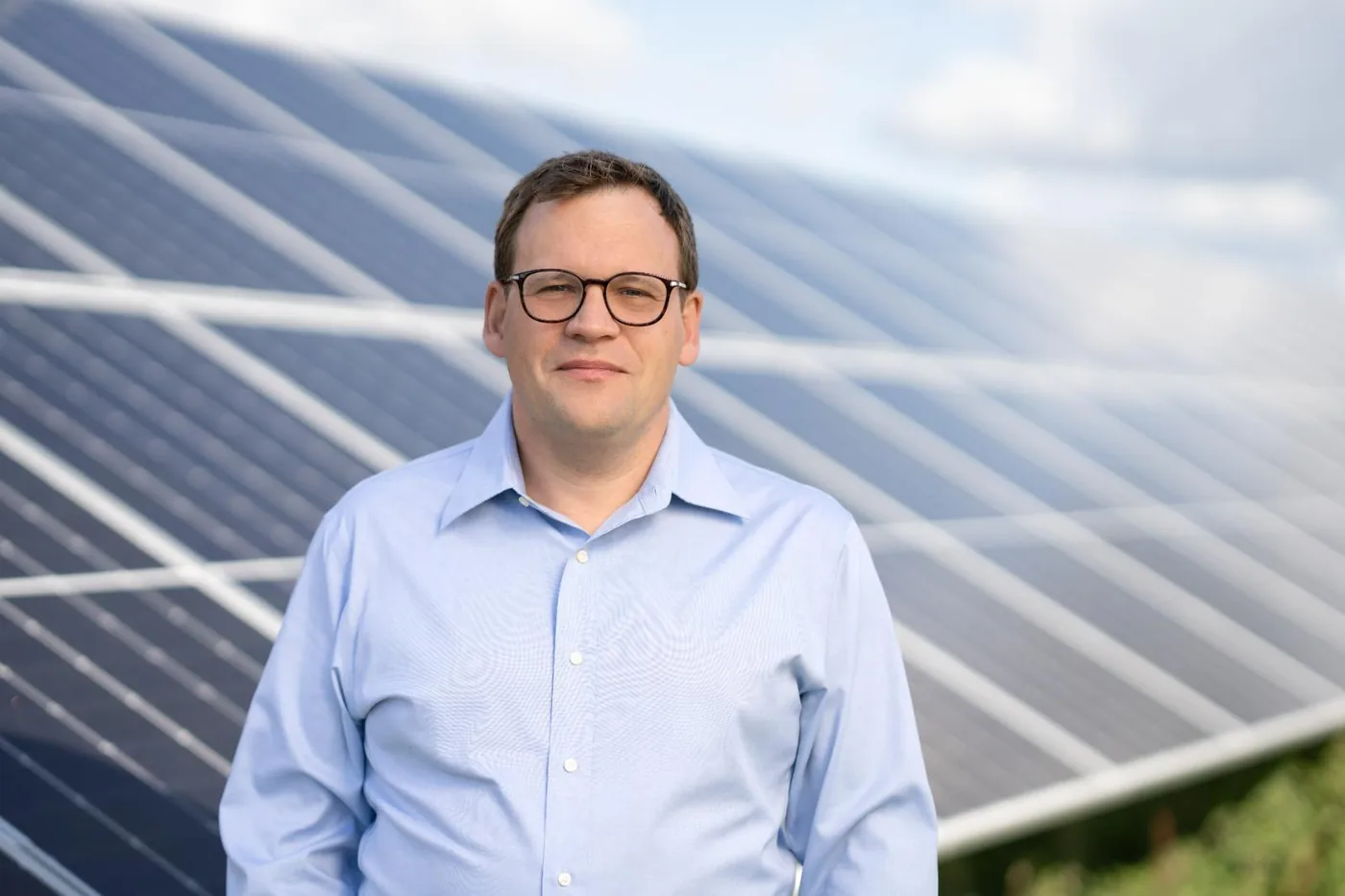 Porträt von Dr. Mark-Oliver Otto vor Solarmodulen