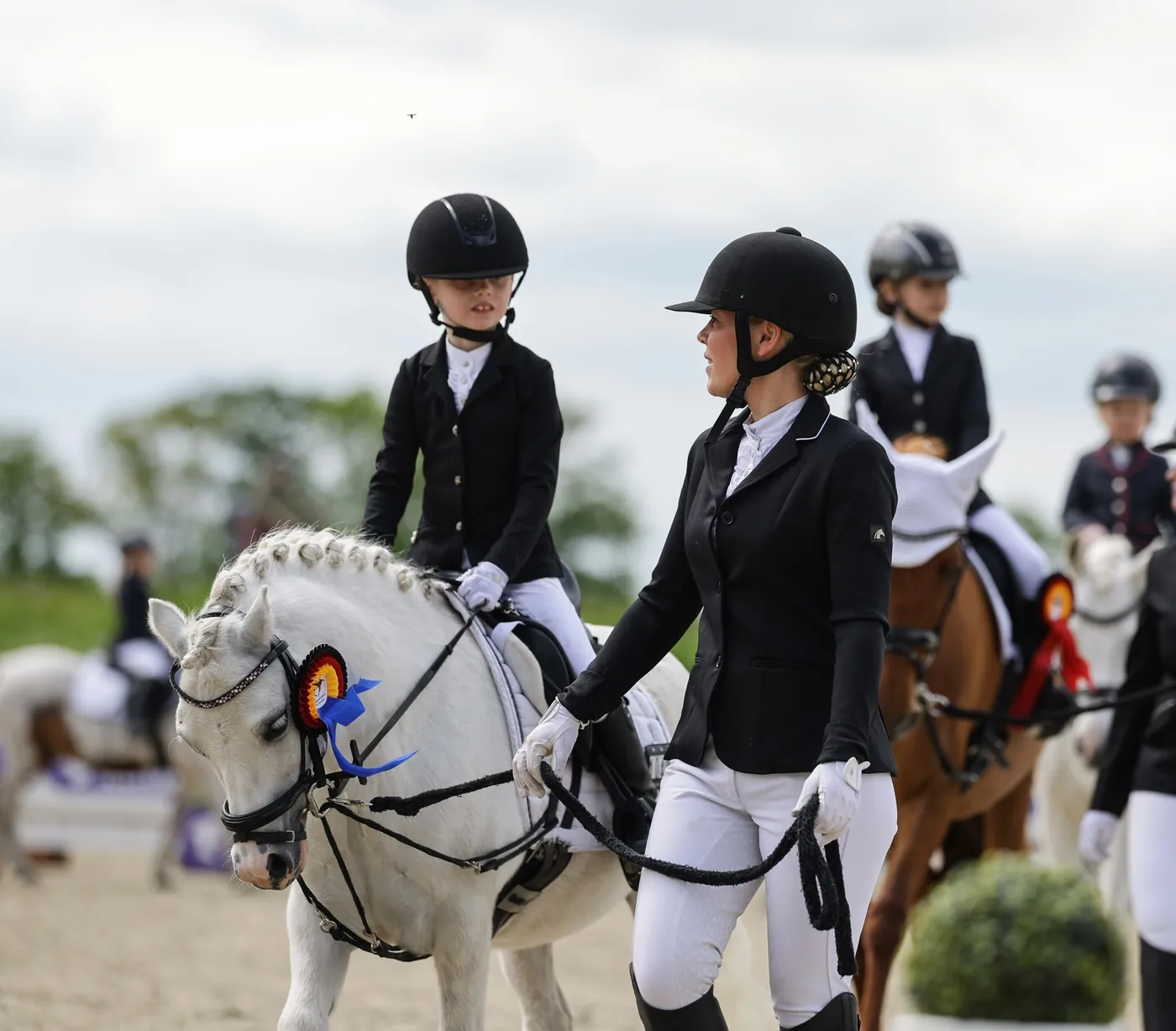 Miriam Westphal begleitet ein Kind bei einem Reitturnier